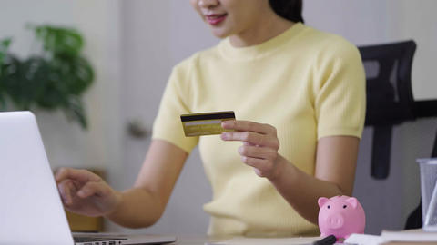 Young Woman Holding Credit Card While Using Laptop for Online Banking and