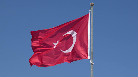 National Turkish flag waving fast at clear blue sky close-up