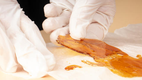 concentrated cannabis resin in hands, golden wax
