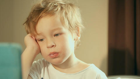 Boy having breakfast watching cartoons on pad