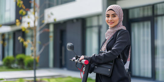 Smiling Muslim Woman Riding an Electric Scooter