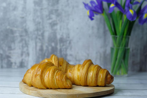 Some fresh croissants on a wooden surface