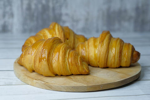 Some fresh croissants on a wooden surface