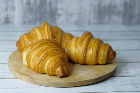 Some fresh croissants on a wooden surface