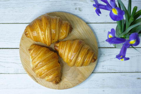 Some fresh croissants on a wooden surface