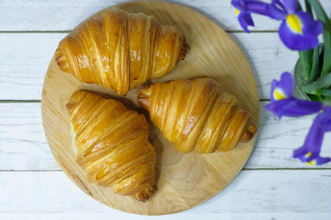 Some fresh croissants on a wooden surface
