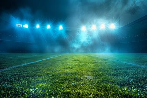 Modern Football Stadium Illuminated by Blue Spotlights at Night