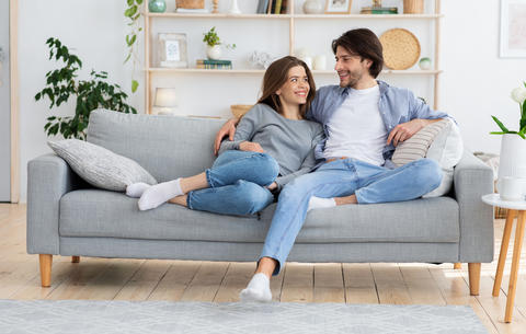 Couple in love hugging on sofa, looking at each other