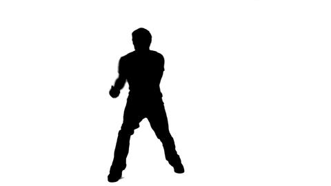 Silhouette of a man singing into a microphone