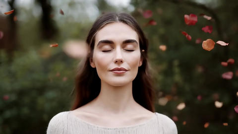 Aromatic caucasian woman basking in the wind amidst falling leaves