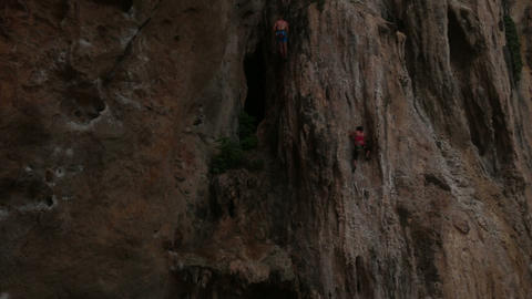 climber climbing a cliff with insurance