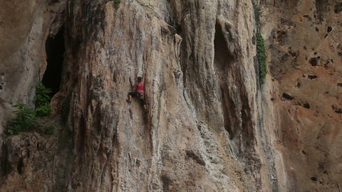climber climbing a cliff with insurance
