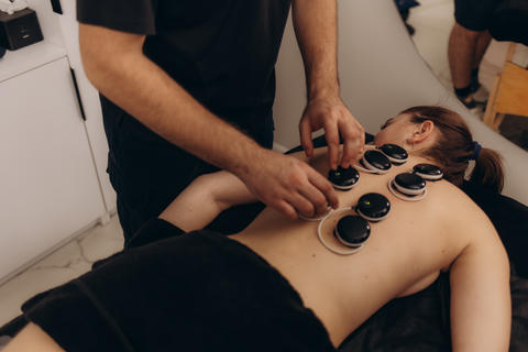 Male therapist maiking rehabilitational procedures with electrical stimulation