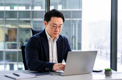 Professional Businessman Working on Laptop in Modern Office Setting