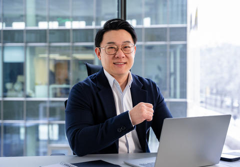 Confident Businessman Working in a Modern Office Environment Using a Laptop