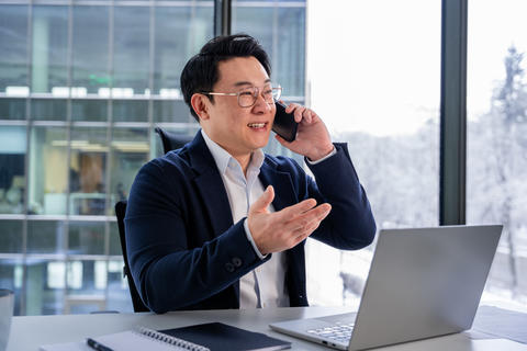 Professional Asian Businessman on Phone Call in Modern Office Setting