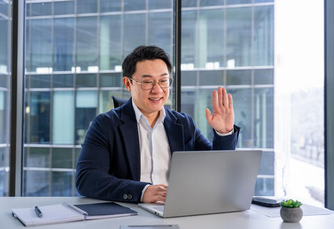 Professional Businessman in Video Meeting at Modern Office Desk