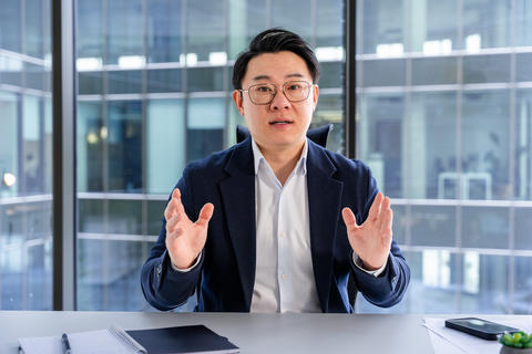 Professional Asian Businessman Discussing Strategies in a Modern Office Setting