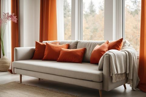 Modern Sofa with Orange Pillows and Knit Blanket by Large Window