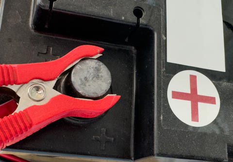A battery terminal with a red clamp connected to the positive contact
