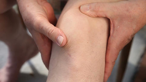 man moves his kneecap around