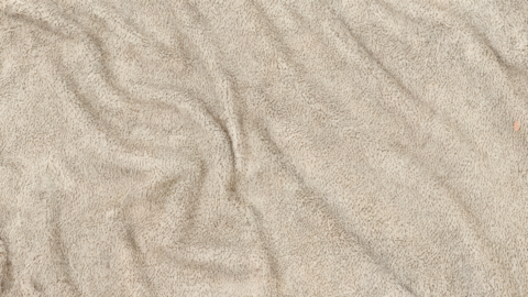 Light taupe suede fabric with soft folds, luxury textile background, macro close up