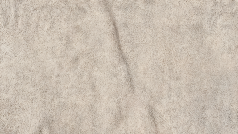 Warm beige suede fabric texture, soft luxury textile background, macro close up