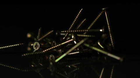 Screws falling on black surface