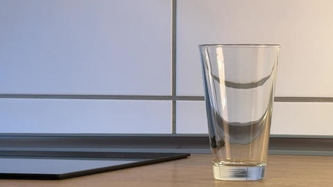 Filling a glass with cola slowly, pouring the cold drink into the glass