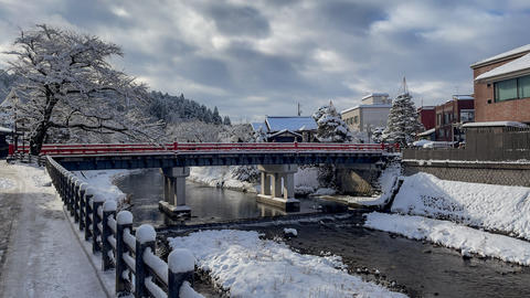 Charming townscape with a red bridge over a partially frozen river in winter