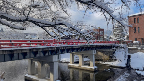 Red bridge over a river in a snowy landscape, classic winter scenery