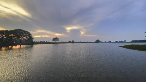 Tranquil lake or reservoir at sunset, with a vibrant sky on the horizon