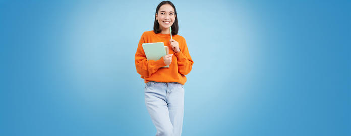 Education and students. Happy asian woman, holding notebooks and laughing, smiling at camera, enjoys