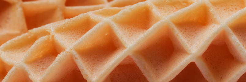 Crispy golden cone wafer with uneven diamond texture and rich color captured in
