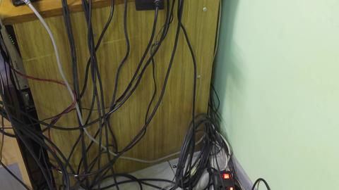 A tangle of electrical wires connected to a power strip, scattered in disarray