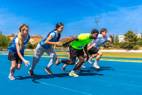 Athletes running on blue track during competition