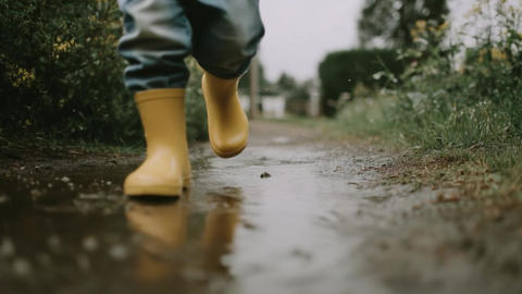 Yellow Rain Boots Walking on Wet Path, Outdoor Adventure and Nature