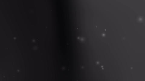 Glowing particles float on black gray background