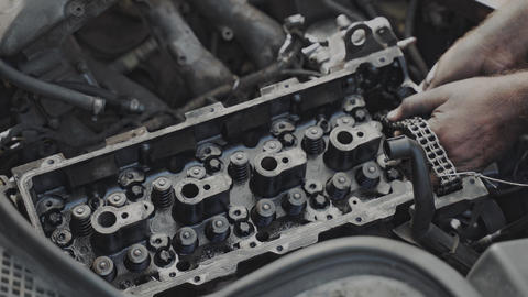 A skilled mechanic is fixing an engine head, demonstrating expertise in