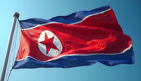 North Korean flag waving in the wind against a clear blue sky, representing