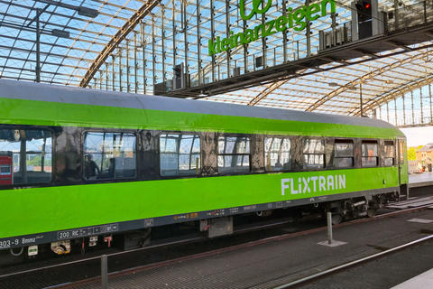 Berlin, Germany, May 26, 2025: Modern Green FlixTrain at Urban Glass Station Platform for Eco