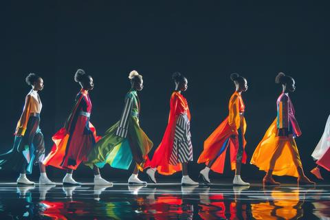 Models showcase vibrant clothing during a fashion runway show in