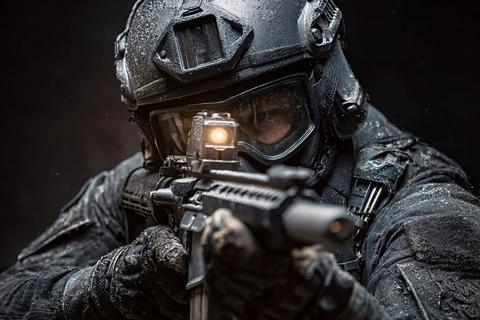 Special forces soldier aiming with assault rifle during night operation