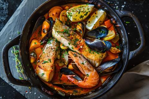Seafood stew served in a rustic bowl with fresh herbs and crusty
