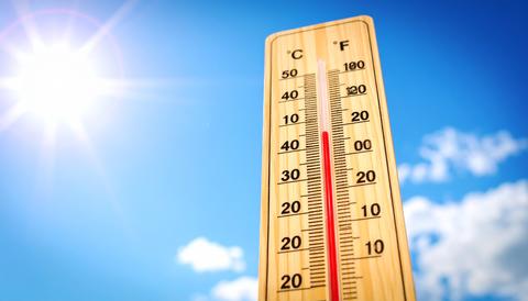 Scorching hot day: Thermometer, sun, and blue sky
