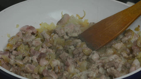 Cooking. Roasting pieces of meat with onion in a frying pan