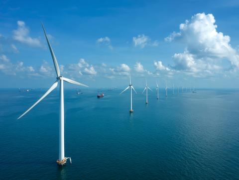 Offshore wind turbines in the ocean under blue sky