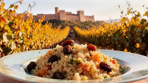 Fluffy Couscous With Raisins And Dried Fruits On Terrace Beneath Golden Vines, Soft Shaded Ambiance