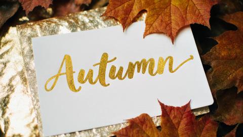 Gold Ink Autumn Script on White Card with Metallic Leaves, Shimmering Foil Surface, Festive Seasonal
