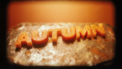 Glittery Orange Autumn Letters on Reflective Metal, Warm Amber Gradient Glow, Festive Seasonal